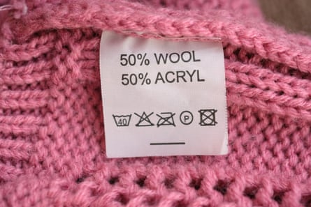 50% wool and 50% acryl. Fabric composition white clothes label on pink texture background.