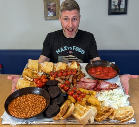 Max Stanford sits at a table with lots of food in front of him.