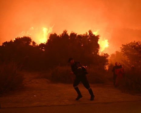 Firefighters work to extinguish a wildfire near the city of Patras, western Greece.