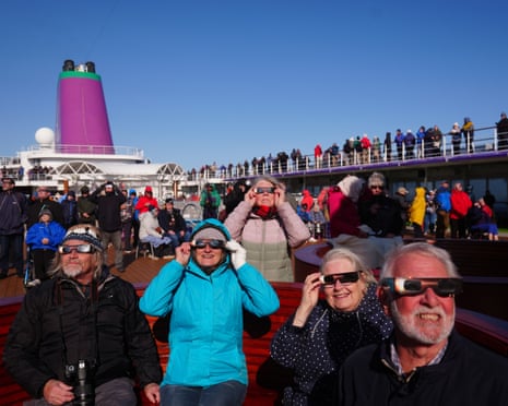 Passengers on board the Ambassador cruise ship Ambition using special eclipse glasses to watch the total solar eclipse off the coast of Greenland.