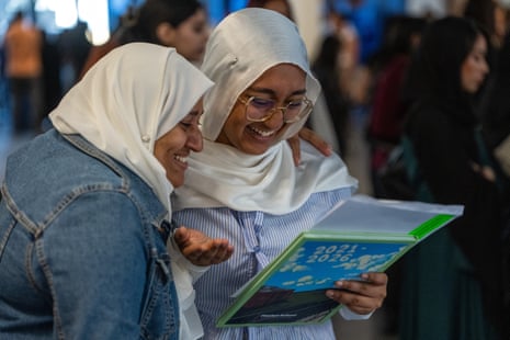 A girl smiles as she reads her results with her mum.