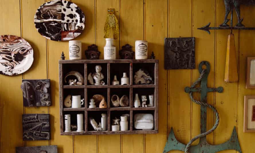 The yellow bathroom with collections on the wall, including a boat anchor