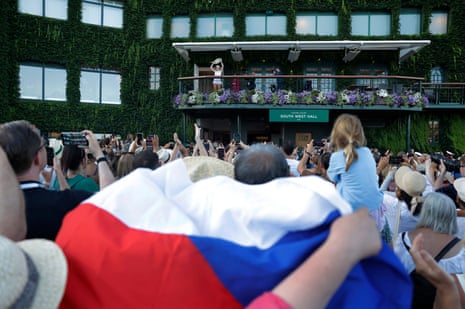 Linda Noskova shows off the Venus Rosewater Dish to fans waving a Czech flag outside Centre Court