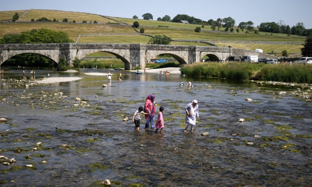 People wading in the River Wharfe, in Burnsall, Yorkshire