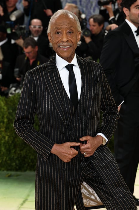 man in black pinstripe suit smiles