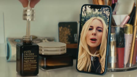 A woman on FaceTime on an iPhone next to a serum bottle