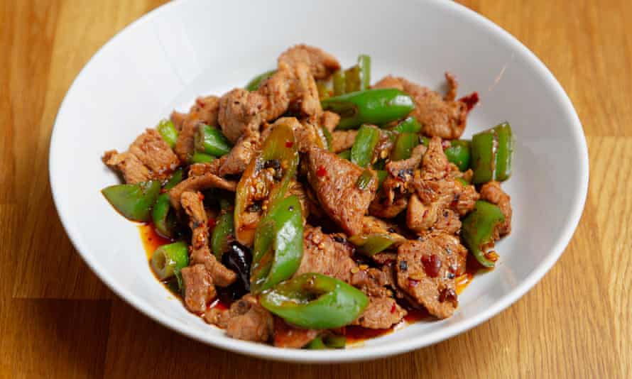 Stir-fried pork with green peppers in a white bowl