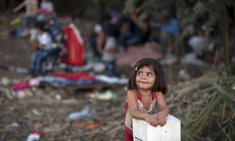 A Syrian girl leans on a border stone on the Serbian border with Hungary
