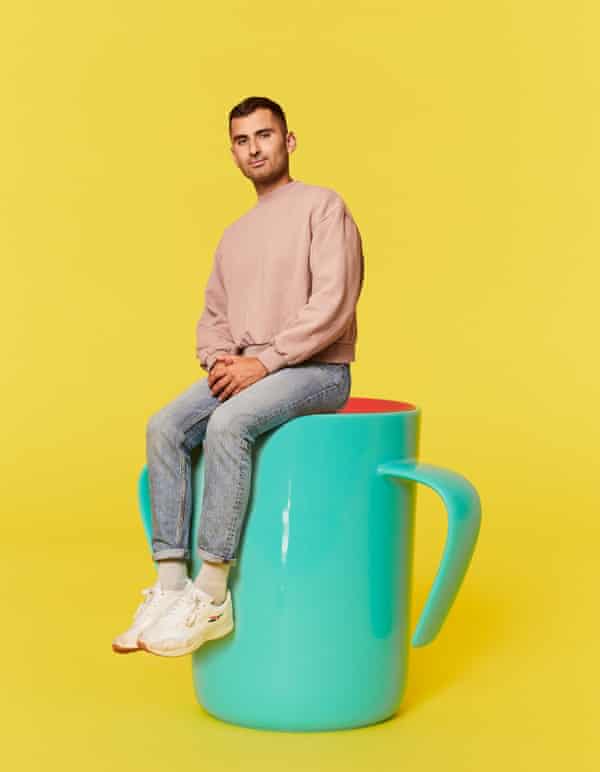 Michael Segalov sits connected  an oversized cupful  for a baby