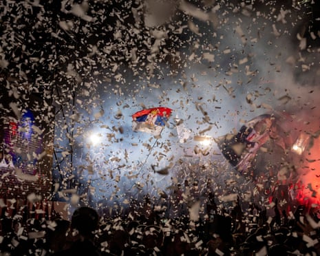 Supporters wave flags amid falling confetti at Vucic's pre-election rally in Niš, Serbia