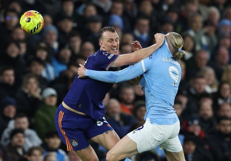 Newcastle United's Dan Burn grabs the shirt of Manchester City's Erling Haaland.
