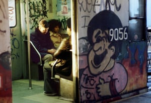 a Willy Spiller photo titled "Sunny Stop, 1982" - a view through the open doors of a NYC subway train covered in graffiti, with passengers visible inside sitting at close quarters in a corner bench