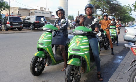 Two rows of drivers sit on green motorbikes.