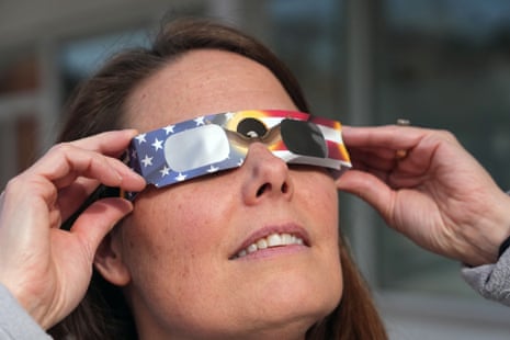 A person holds paper glasses decorated with US flag