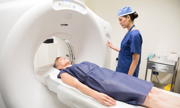 A radiologist with a patient having a PET-CT scan, which can help doctors spot tumours.