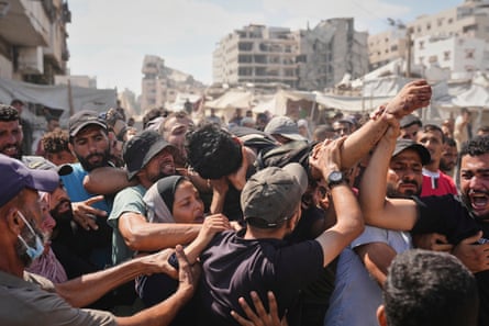 Mourners carrying the body of a Palestinian man who was killed while trying to reach aid trucks entering northern Gaza through the Zikim crossing with Israel.