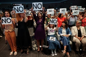 A group of women hold up signs saying 'no'
