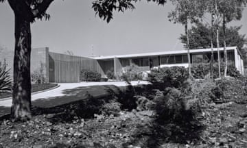 black and white image of ranch-style home under trees