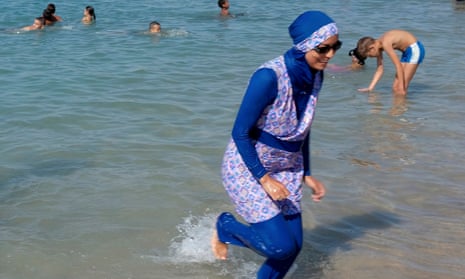 A woman wearing a burkini paddles in Marseille