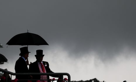 Racegoers try to shelter from the torrential rain at Royal Ascot.