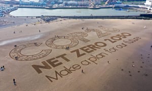 A large sand artwork reading 'Cop26: net zero 2050. Make a plan for our future'