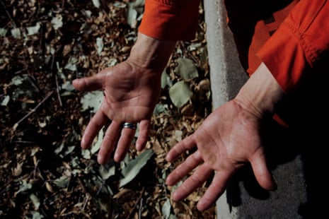calloused hands of a man in an orange prison jumpsuit