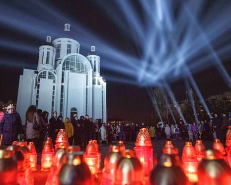 People attend a ceremony at a memorial for killed civilians to mark the fourth anniversary of the liberation of Bucha, Ukraine.