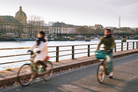 Two people riding bikes alongside the Seine