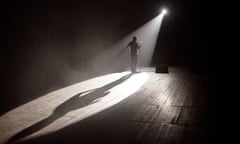 Stand up comedian on stage in the beam of light.<br>2F4BJ2Y Stand up comedian on stage in the beam of light.
