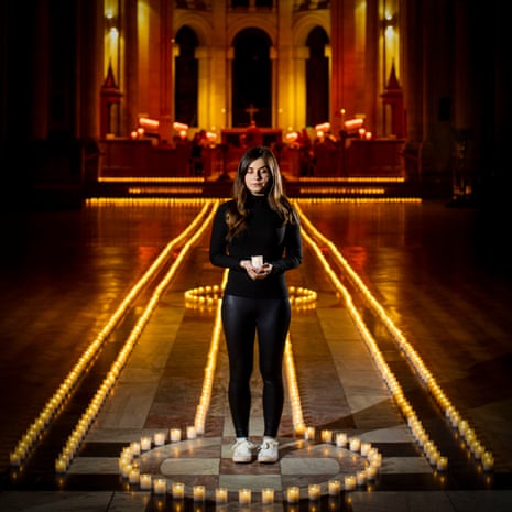 Holly Wilson, whose grandmother Ada Wilson passed away during the pandemic, stands in Belfast Cathedral among 2,100 tea-lights - one for each life lost to Covid in Northern Ireland.