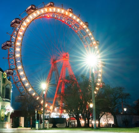 Image of a ferris wheel lit up, taken at night