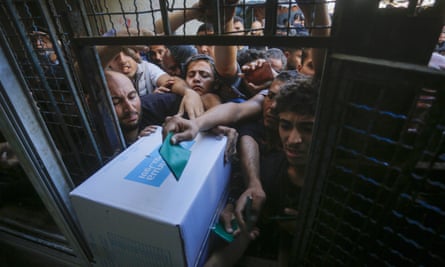 Palestinians in Gaza queue for aid parcels distributed by Unrwa.