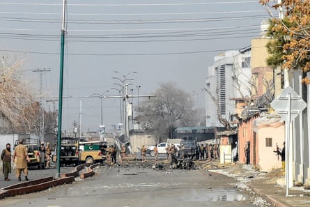 A street scene showing military personnel and damaged buildings
