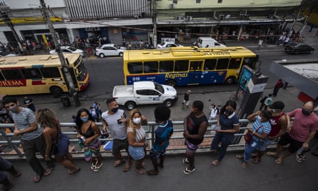 People line up to get a Covid-19 vaccine shot at a train station during a vaccine campaign for people over age 20 in Duque de Caxias, Brazil.
