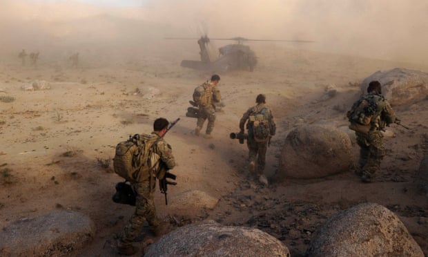 Australian army soldiers walk towards a waiting helicopter