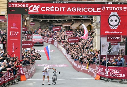 Tadej Pogacar bows after crossing the line in Siena