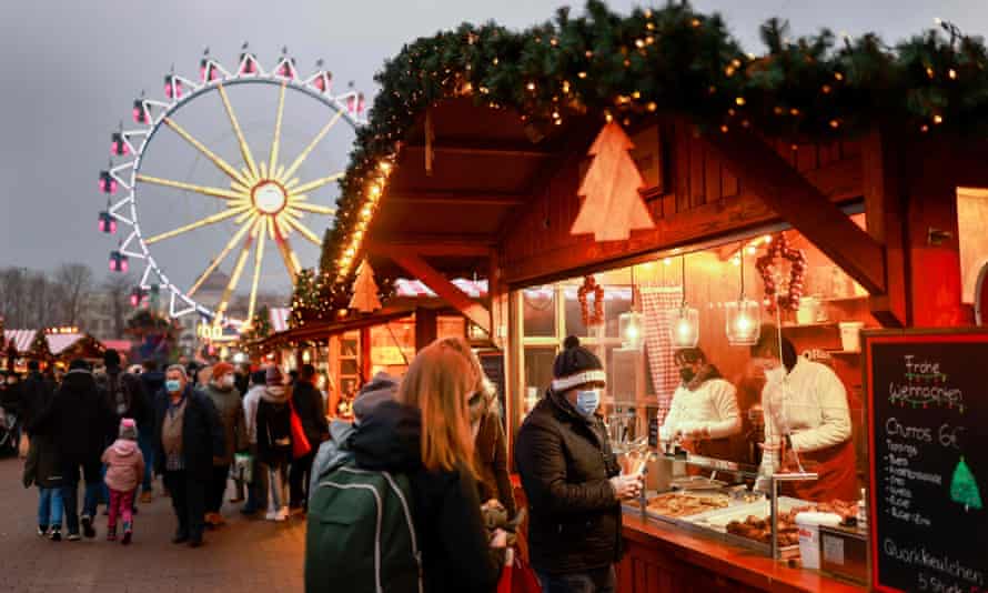 People visit a stall at a Christmas market near Alexanderplatz in Berlin on 5 December as Germany battles a surge in Covid-19 infections ahead of the holiday season.