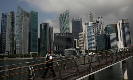 A man passes the city skyline during the coronavirus disease outbreak, in Singapore