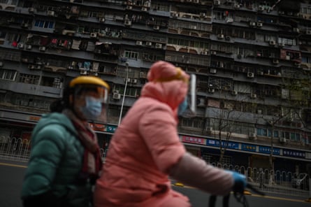 Women wearing face masks ride a scooter on a street in Wuhan on 1 April 2020.