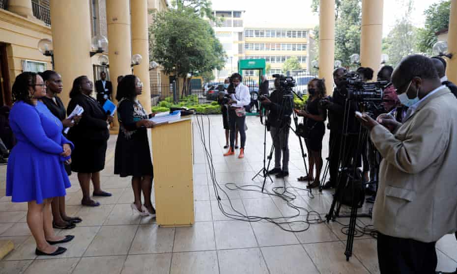 Mercy Mutemi at podium facing news reporters with mics