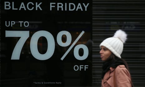 A shopper walks past a Black Friday sign