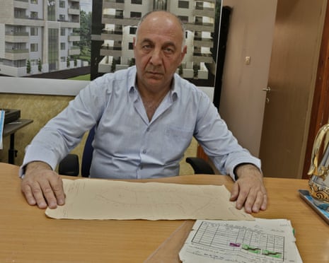 Mohammad al-Sbeih with documents that show his family’s ownership of the property being advertised on Booking.com.