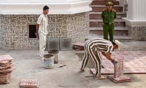 A prisoner lays tiles outside Tu Duc prison.