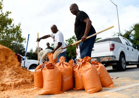 People use shovels to put sand in sandbags
