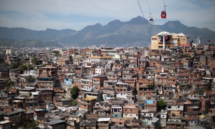 Cable cars travel over the Complexo do Alemao slum in Rio de Janeiro, Brazil