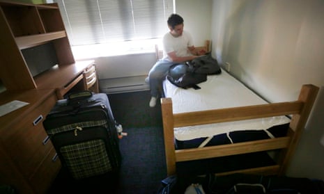 A university student unpacks his luggage inside his room