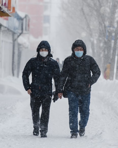 People walk in a street during a snowfall in Sakhalin, Russia.
