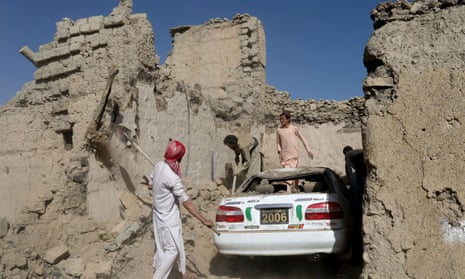 Afghan people try to retrieve a car from the debris of damaged houses after the recent earthquake in the Barmal district of Paktika province, Afghanistan