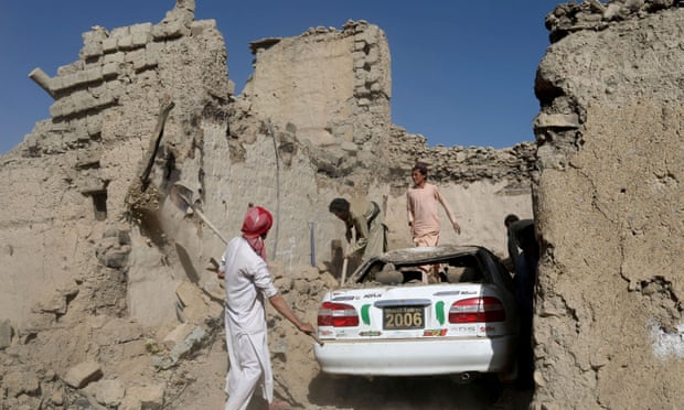 Afghan people try to retrieve a car from the debris of damaged houses after the recent earthquake in the Barmal district of Paktika province, Afghanistan