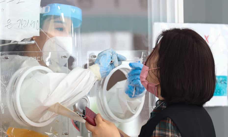 A medical worker takes a sample at a makeshift Covid-19 testing station in Seoul